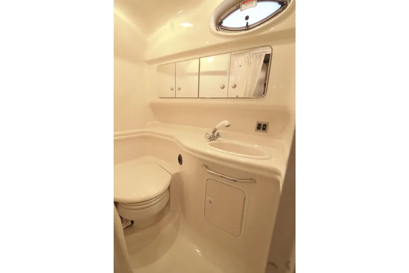 Slide: The Image of 2004 Sea Ray 340 Sundancer bathroom with sink, mirror, and toilet in compact design. - 17