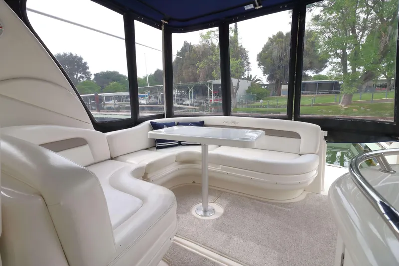 Slide: The Image of Interior of 2004 Sea Ray 340 Sundancer with white seating and table. - 4