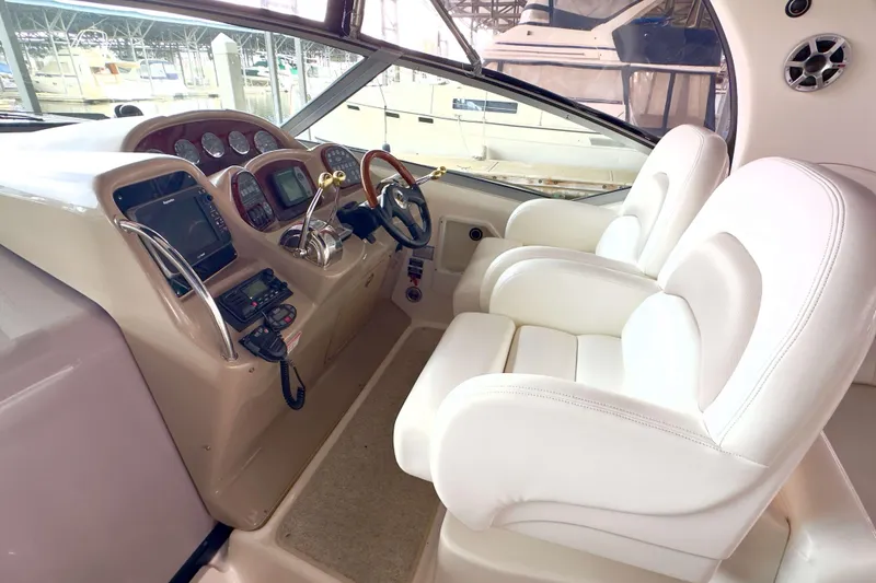 Slide: The Image of 2004 Sea Ray 340 Sundancer helm with white leather seats and modern controls. - 7