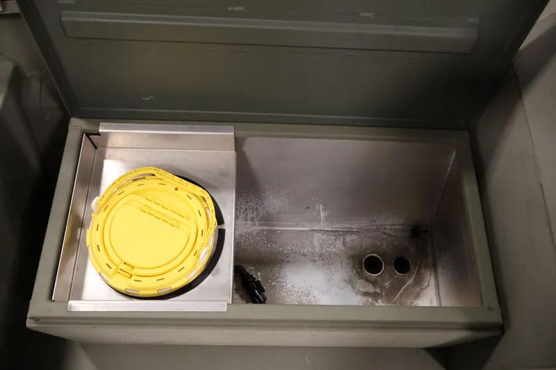 Slide: The Image of 2021 Polar Kraft Sportsman 1760 SE boat compartment with yellow lid and drainage holes. - 20