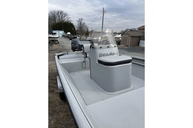 Slide: The Image of 2025 SeaArk Shadow 18T boat with console, parked outdoors on gravel. - 4