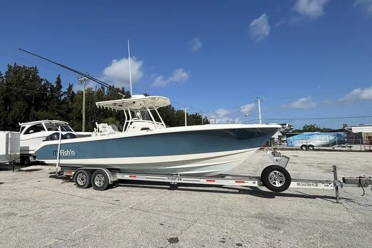 The Image of 2013 Edgewater 318CC boat on trailer under clear blue sky. - 0