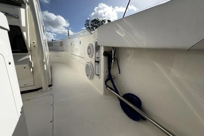 Slide: The Image of 2013 Edgewater 318CC boat interior with speakers and railing under a blue sky. - 11