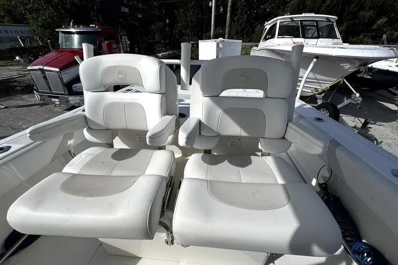 Slide: The Image of Two white cushioned seats on a 2013 Edgewater 318CC boat deck. - 12