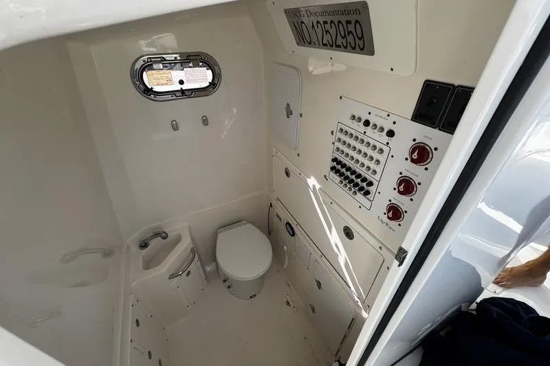 Slide: The Image of Interior of 2013 Edgewater 318CC boat featuring a compact marine bathroom. - 13