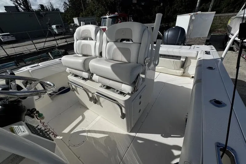 Slide: The Image of 2013 Edgewater 318CC boat interior with dual white cushioned seats and steering wheel. - 14