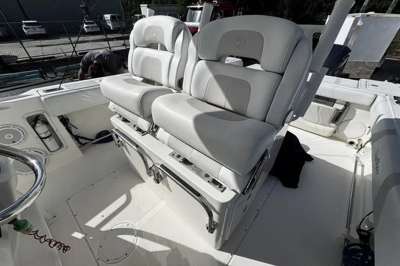 Slide: The Image of 2013 Edgewater 318CC boat interior with dual cushioned seats and storage compartments. - 17