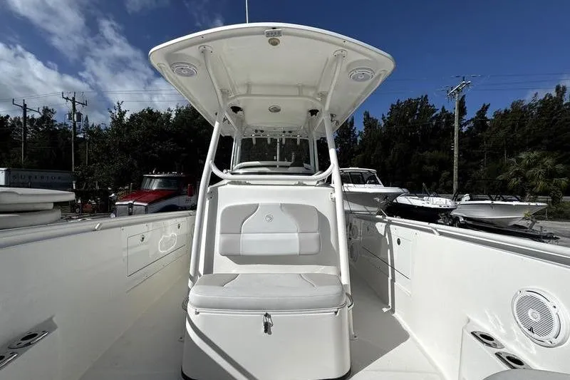 Slide: The Image of 2013 Edgewater 318CC boat with center console and seating, docked under a clear blue sky. - 18