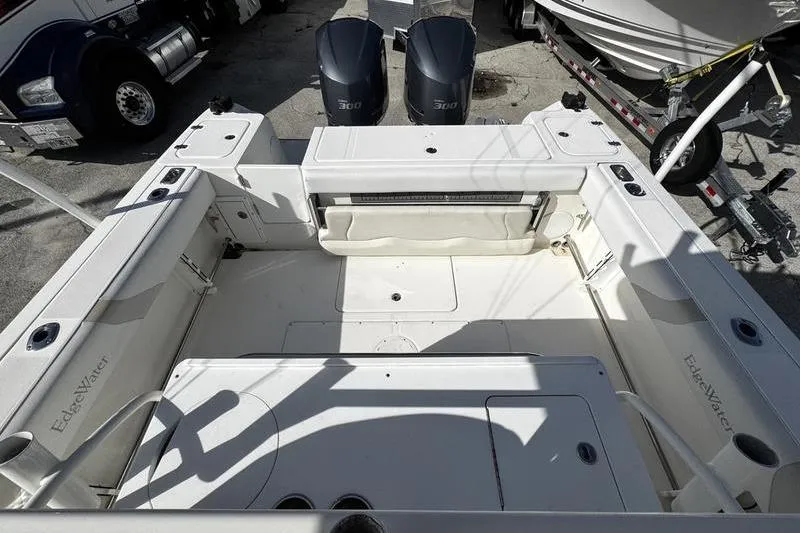 Slide: The Image of 2013 Edgewater 318CC boat interior with twin 300 engines, docked near trucks and trailers. - 19