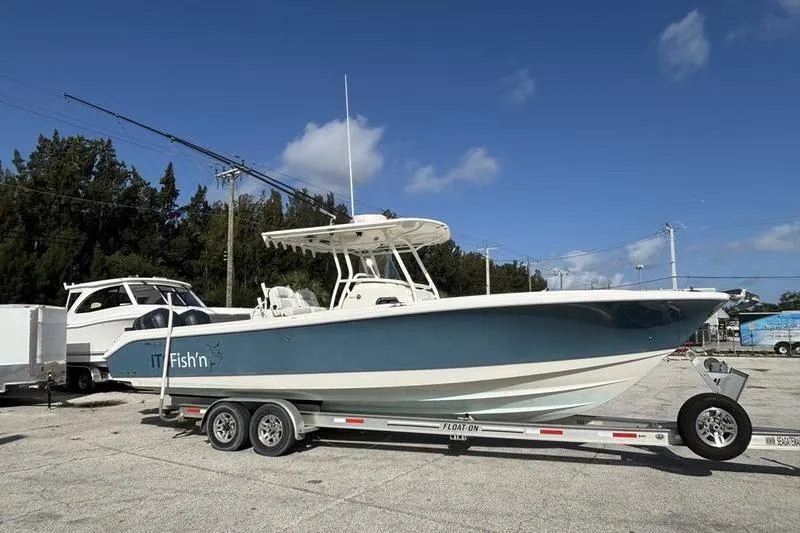 Slide: The Image of 2013 Edgewater 318CC boat on trailer under clear blue sky. - 2