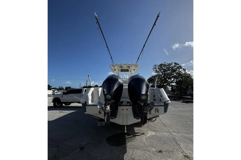Slide: The Image of Rear view of a 2013 Edgewater 318CC boat with dual outboard motors. - 21