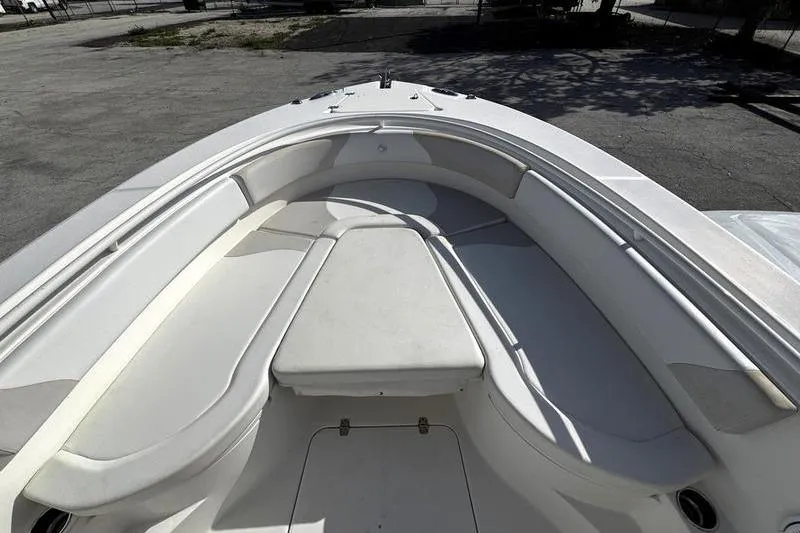 Slide: The Image of Bow seating area of a 2013 Edgewater 318CC boat, featuring cushioned benches. - 22