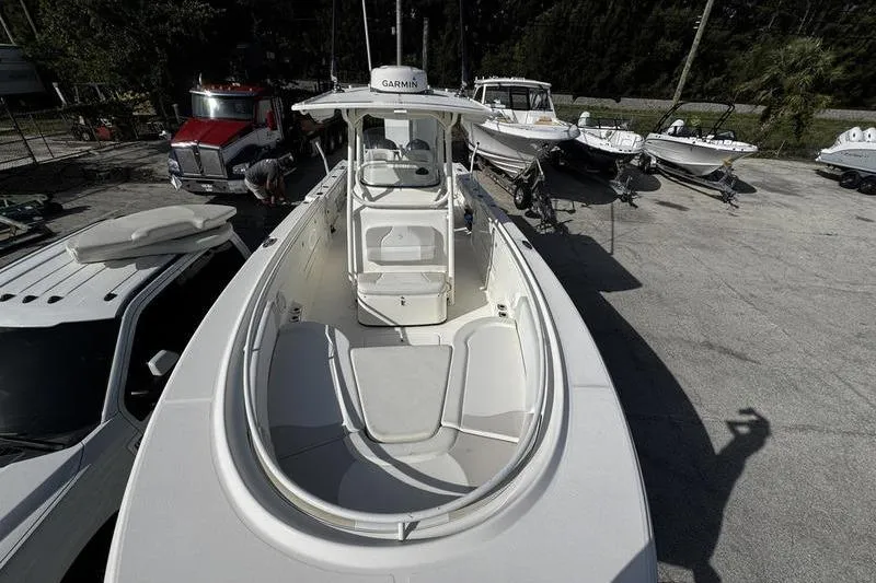 Slide: The Image of 2013 Edgewater 318CC boat parked with other vehicles in a lot. - 28