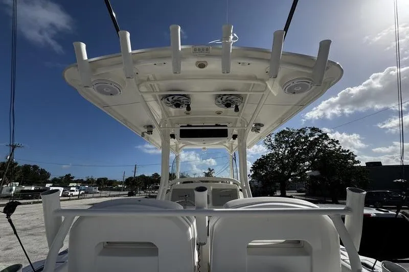 Slide: The Image of 2013 Edgewater 318CC boat with T-top and rod holders under a clear blue sky. - 3