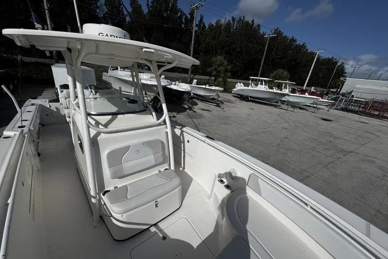 Slide: The Image of 2013 Edgewater 318CC boat with seating, parked outdoors near other boats. - 6