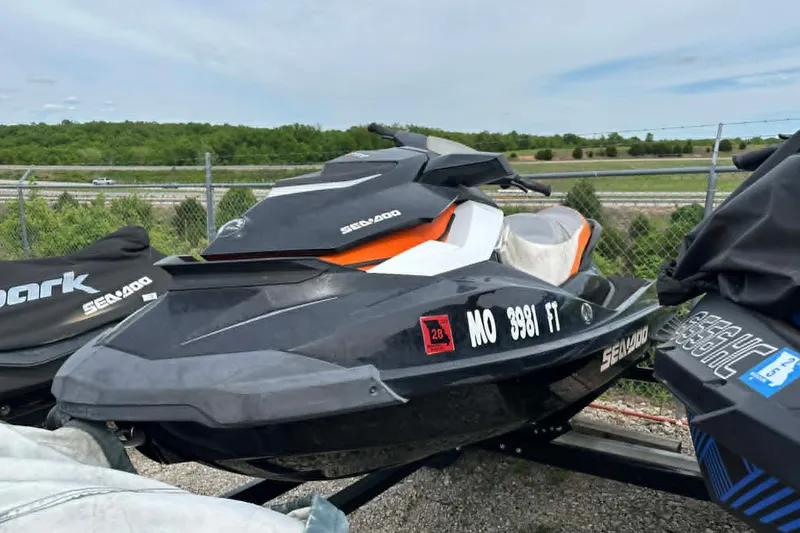 Slide: The Image of 2011 Sea-Doo GTI SE 155 jet ski parked on a trailer, outdoor setting. - 7