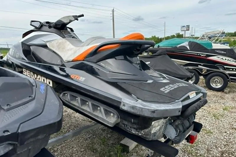 Slide: The Image of 2011 Sea-Doo GTI SE 155 jet ski parked on gravel lot, rear view. - 8