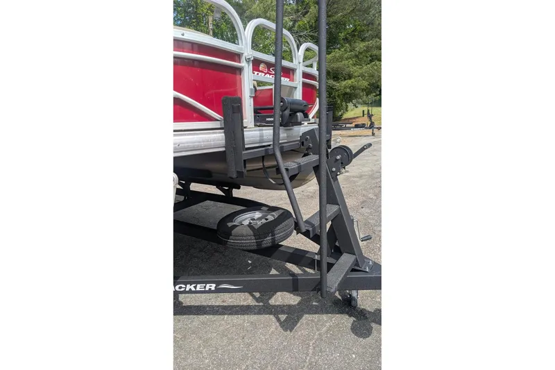 Slide: The Image of 2022 Sun Tracker Fishin' Barge 20 DLX on trailer, featuring red exterior and sturdy frame. - 4