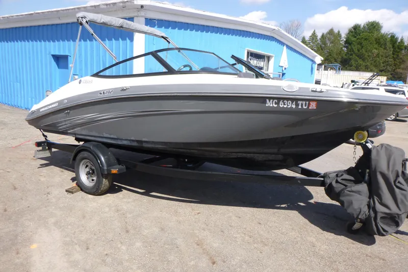 Slide: The Image of 2015 Yamaha Boats SX192 on trailer, parked outside a blue building. - 6