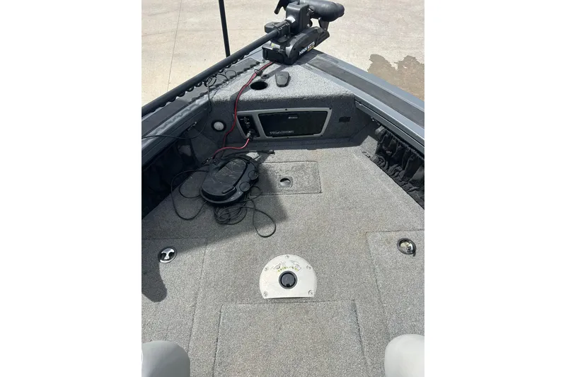 Slide: The Image of 2017 Tracker Targa V-18 Combo boat interior with fishing equipment and carpeted deck. - 11