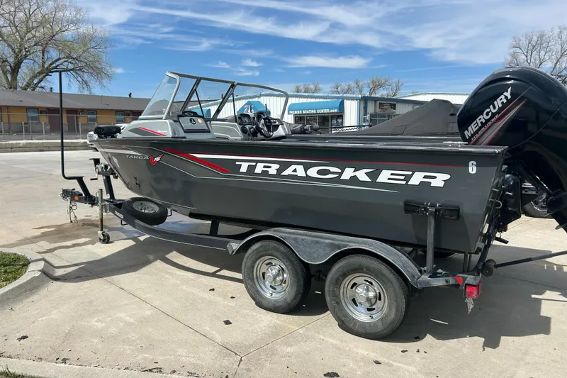 Slide: The Image of 2017 Tracker Targa V-18 Combo boat on trailer, parked outdoors with Mercury engine. - 2