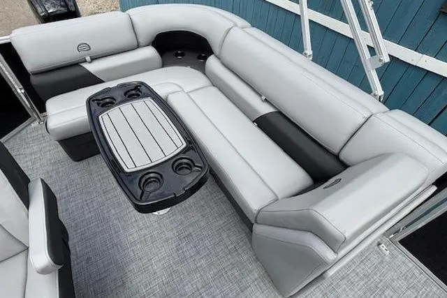 Slide: The Image of 2026 Sun Tracker Party Barge 20 DLX interior with gray seating and table. - 13