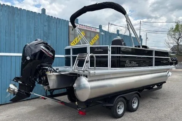 Slide: The Image of 2026 Sun Tracker Party Barge 20 DLX pontoon boat on trailer, featuring Mercury outboard motor. - 3