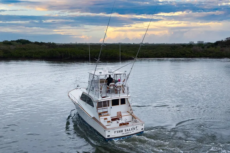 Slide: The Image of 1982 Post 46 Convertible yacht cruising on a serene river at sunset. - 11