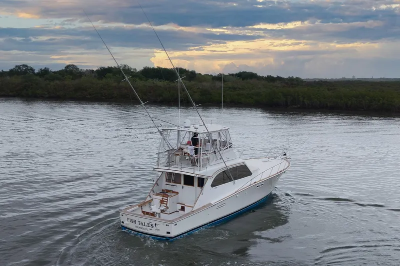 Slide: The Image of 1982 Post 46 Convertible yacht cruising on a serene river at sunset. - 13
