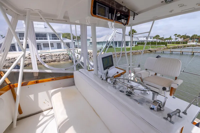 Slide: The Image of 1982 Post 46 Convertible yacht helm with modern controls, overlooking waterfront homes. - 24