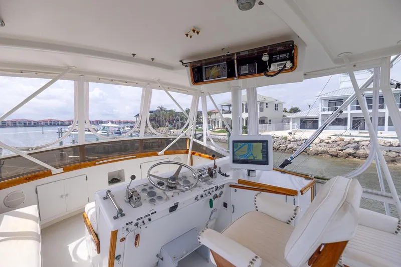 Slide: The Image of Helm of 1982 Post 46 Convertible yacht with navigation equipment, overlooking marina and waterfront homes. - 25