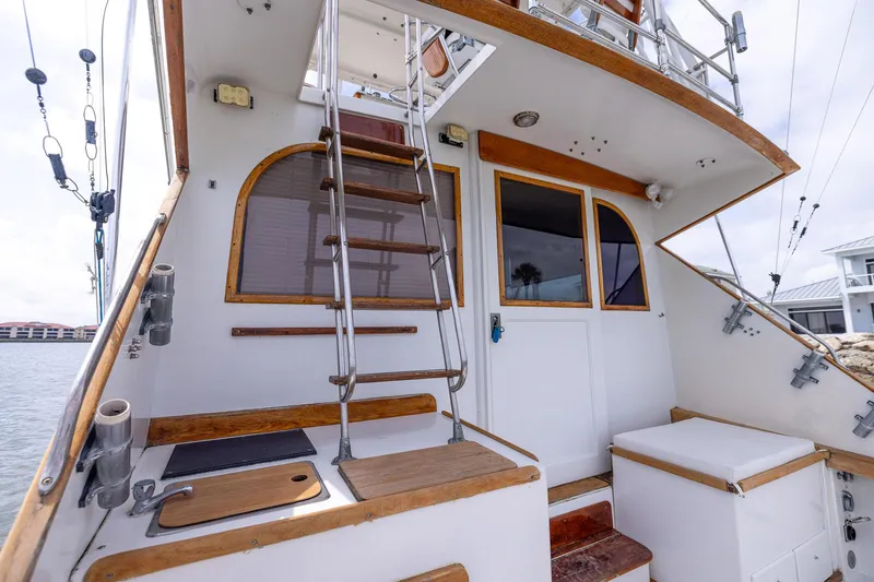 Slide: The Image of 1982 Post 46 Convertible yacht with wooden accents and ladder, docked by the water. - 30