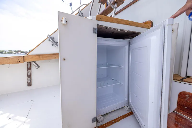 Slide: The Image of Open refrigerator on 1982 Post 46 Convertible boat deck, showcasing interior shelves. - 31