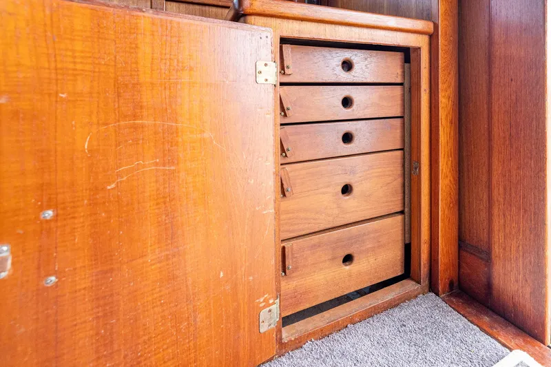 Slide: The Image of Wooden cabinet with open door revealing five drawers, inside a 1982 Post 46 Convertible. - 37
