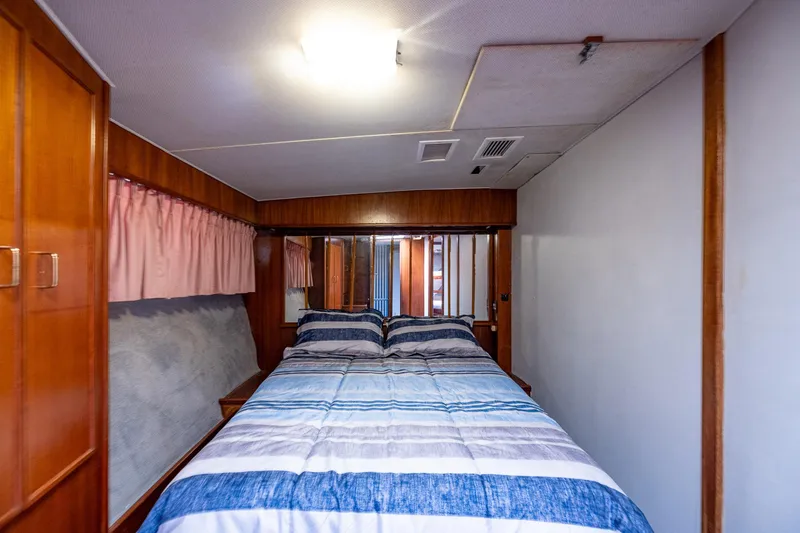 Slide: The Image of Cozy bedroom interior in 1982 Post 46 Convertible yacht with wood paneling and striped bedding. - 40