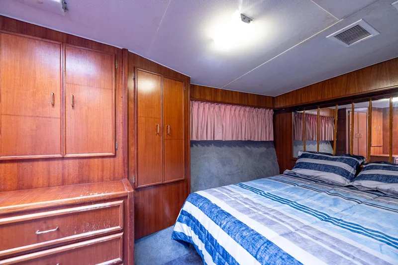 Slide: The Image of Cozy bedroom in 1982 Post 46 Convertible yacht with wood cabinets and striped bedding. - 41