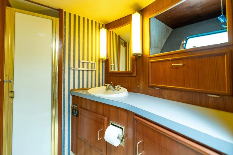 Slide: The Image of Vintage 1982 Post 46 Convertible yacht bathroom with wood cabinetry and striped wallpaper. - 42