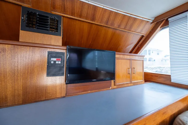 Slide: The Image of 1982 Post 46 Convertible yacht interior with wood paneling, TV, and storage cabinets. - 48