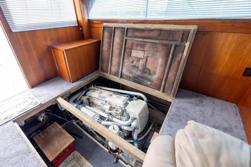 Slide: The Image of Engine compartment of a 1982 Post 46 Convertible yacht, featuring a visible engine and wooden interior. - 55