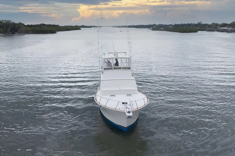 Slide: The Image of 1982 Post 46 Convertible yacht cruising on a serene waterway at sunset. - 8
