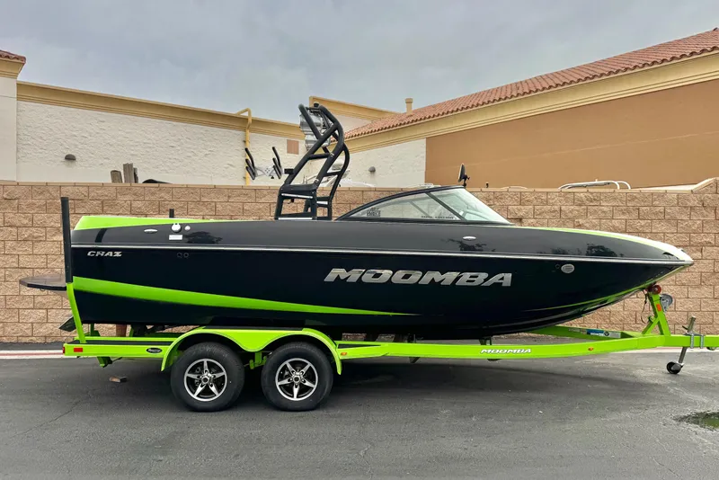 The Image of 2016 Moomba Craz boat on a neon green trailer, parked outdoors. - 0