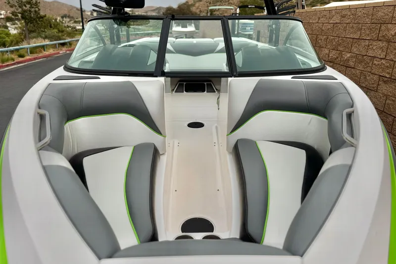 Slide: The Image of 2016 Moomba Craz boat interior with gray and green seating, open bow design. - 10
