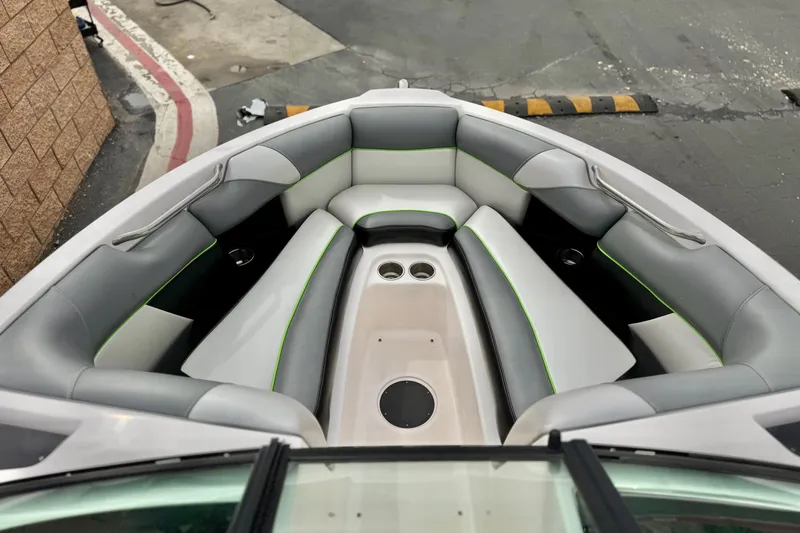 Slide: The Image of 2016 Moomba Craz boat interior with gray and white seating, green accents, and cup holders. - 11