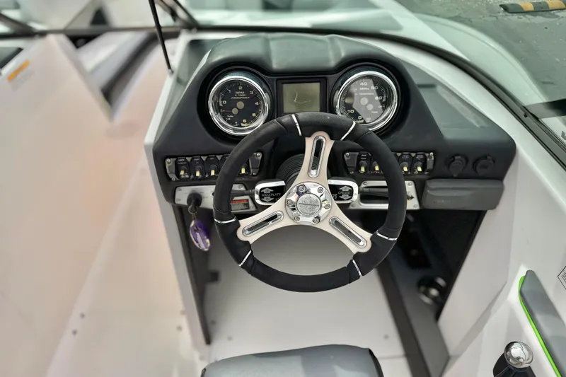 Slide: The Image of Steering wheel and dashboard of a 2016 Moomba Craz boat, featuring gauges and controls. - 27