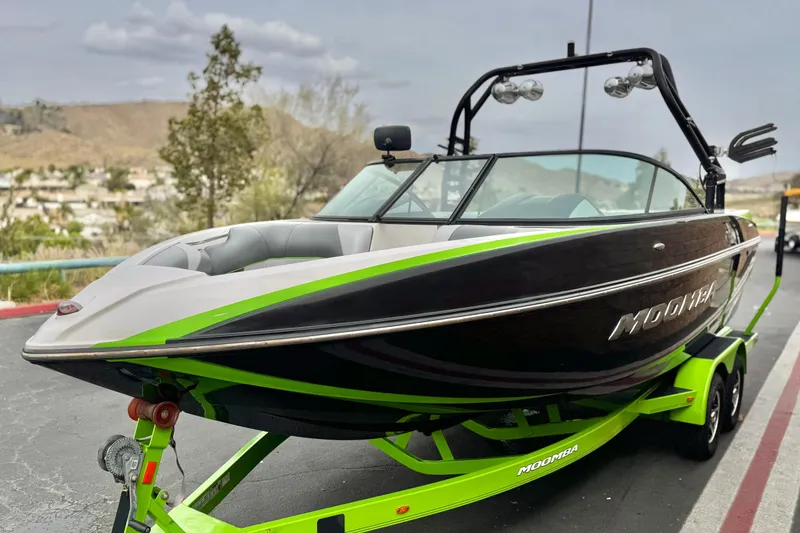 Slide: The Image of 2016 Moomba Craz boat on trailer, black and green design, parked outdoors. - 3