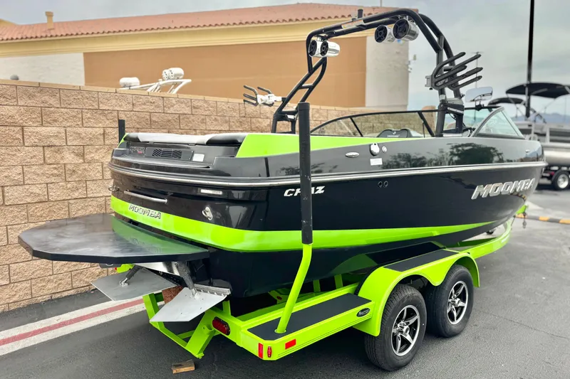 Slide: The Image of 2016 Moomba Craz boat with vibrant green accents on a trailer. - 5