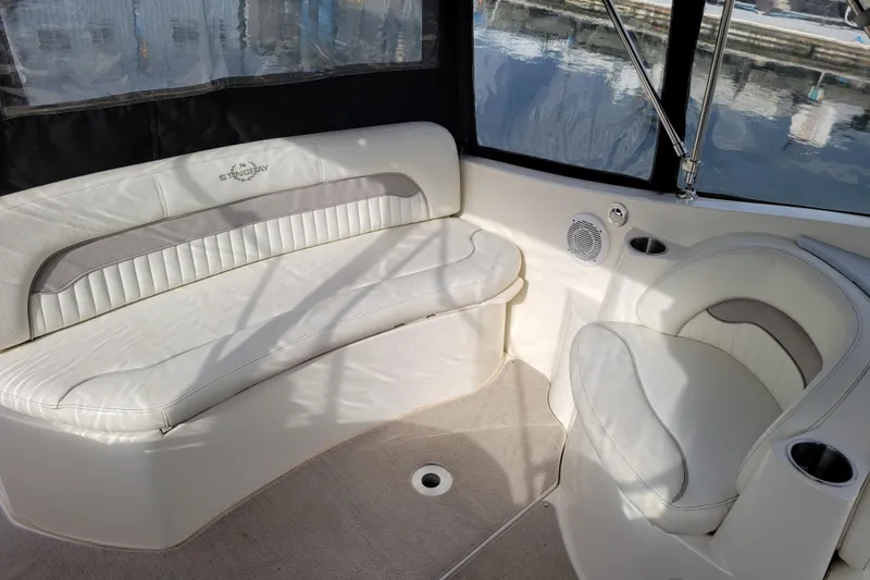 Slide: The Image of Interior of a 2007 Stingray 250 CS boat with white seating and windows. - 10