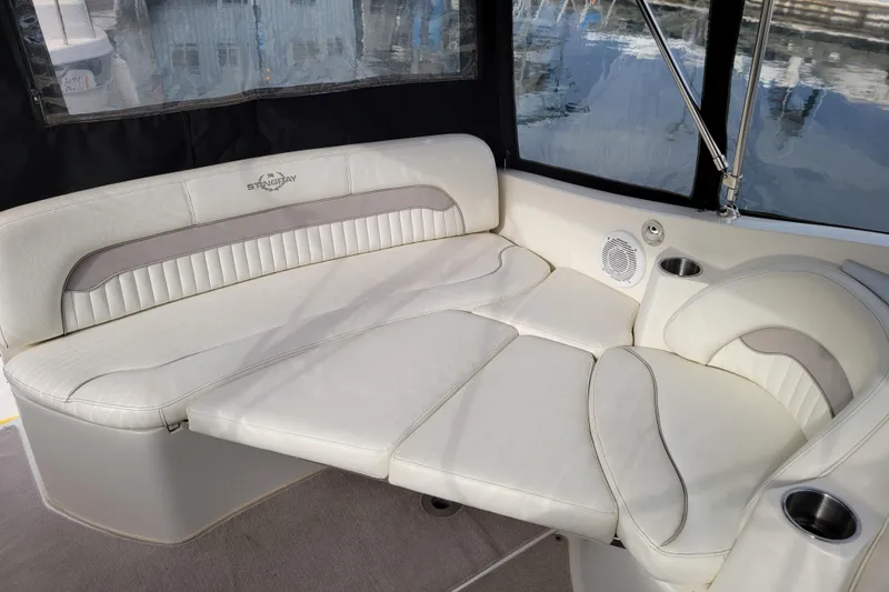 Slide: The Image of 2007 Stingray 250 CS boat interior with white cushioned seating and cup holders. - 11
