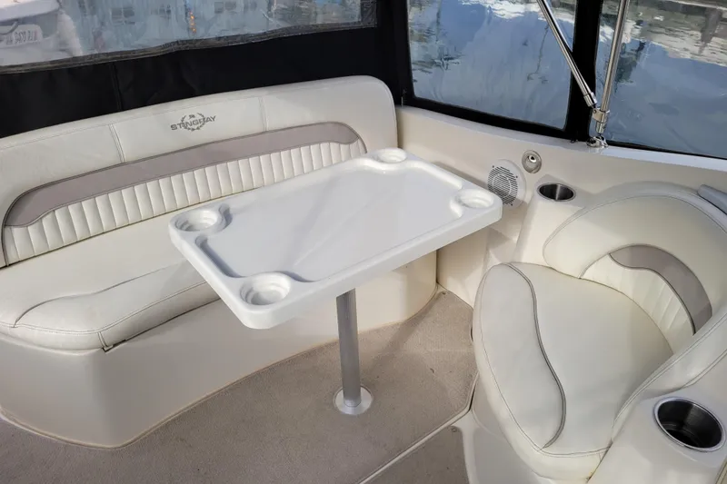 Slide: The Image of Interior of a 2007 Stingray 250 CS boat with white seating and table. - 12