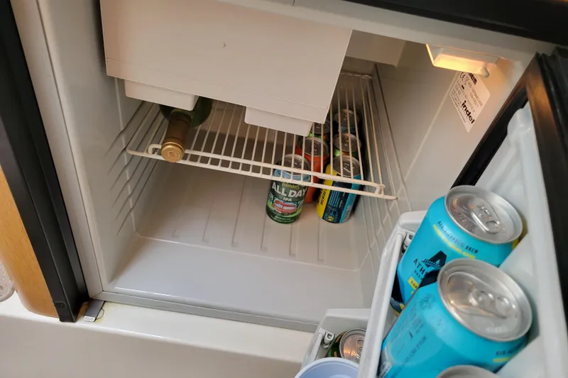 Slide: The Image of Mini fridge stocked with assorted beverages inside a 2007 Stingray 250 CS boat. - 26